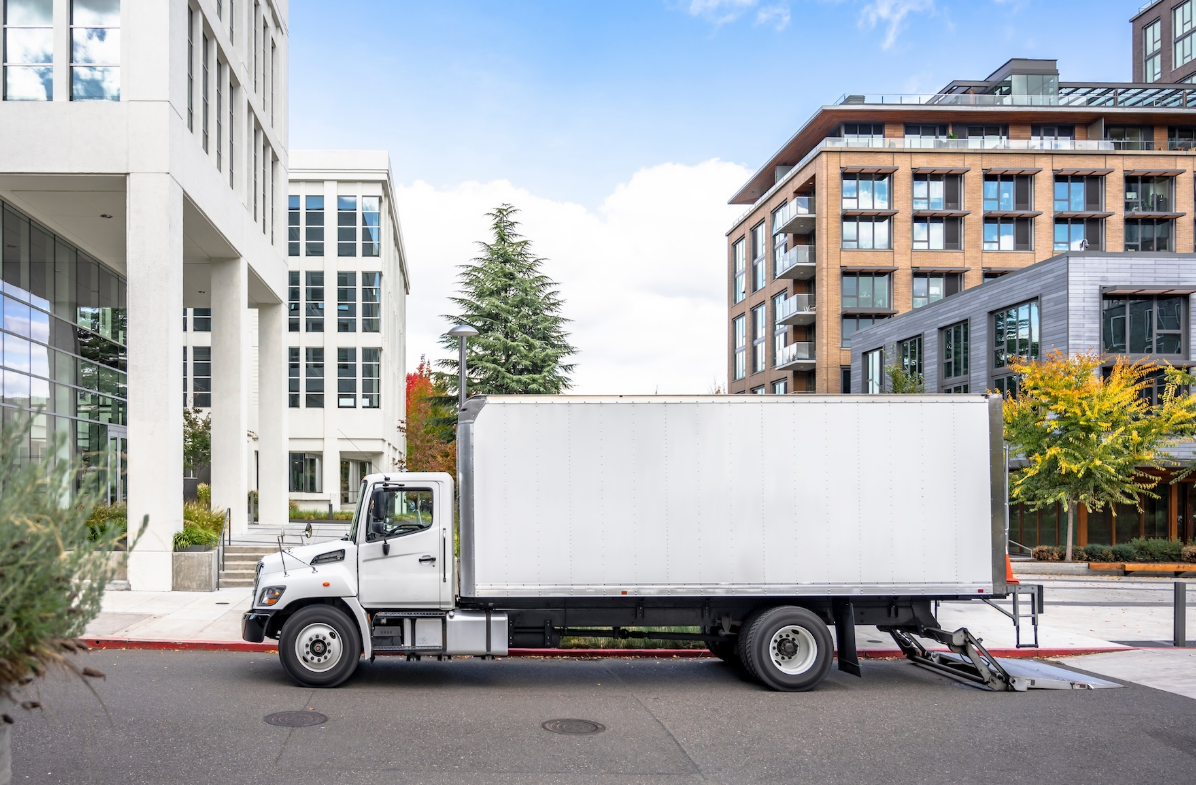 White box truck driving on a highway, representing reliable box truck insurance services offered by an insurance company in Lancaster, Ohio.